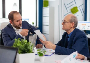Dos empresarios analizan documentos y gráficos durante una reunión en una oficina moderna